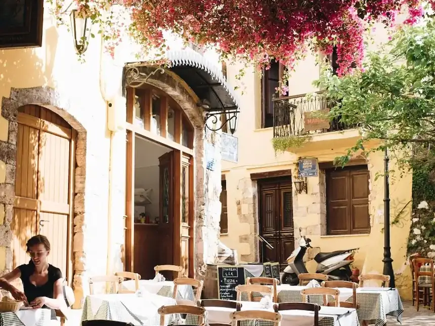 La terraza de un restaurante en un callejón con buganvillas