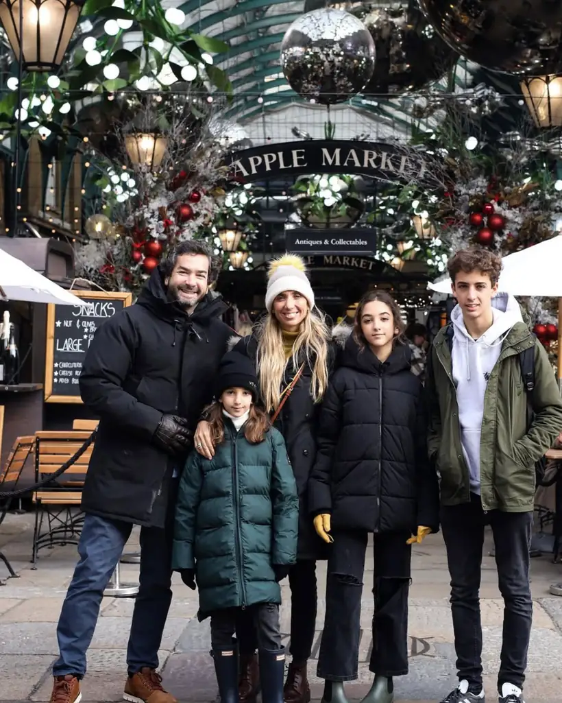 Una familia en la entrada de un mercado navideño