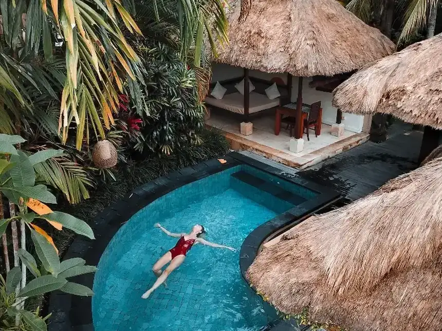 Una piscina entre palmeras en un alojamiento